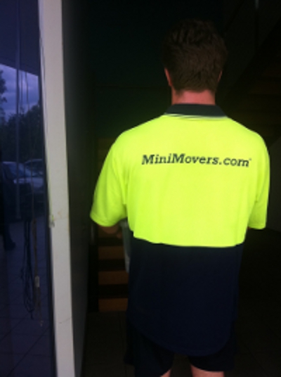 Removalist wearing a MiniMovers.com hi-vis shirt standing in a doorway during an office move