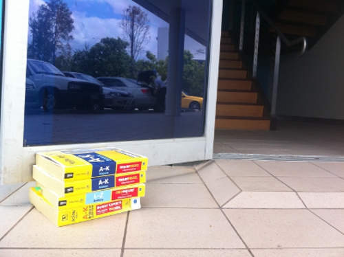 Stack of Yellow Pages phone directories propping open a glass office door during the Matter Solutions office move