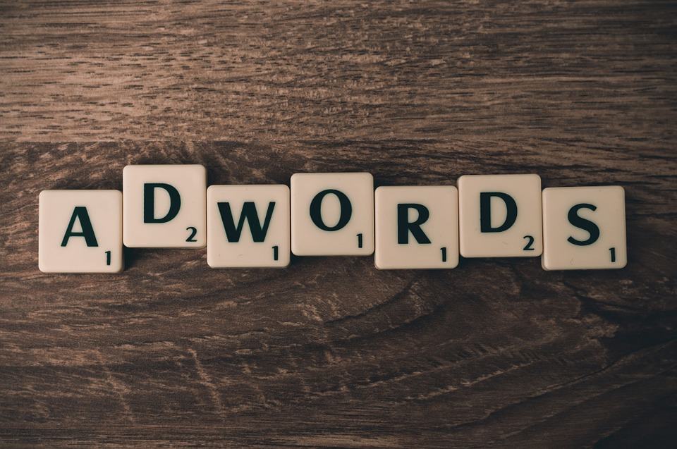 Scrabble tiles spelling ADWORDS on a wooden surface, representing Google AdWords quality score