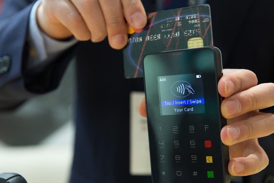 Customer inserting a credit card into a contactless card payment terminal