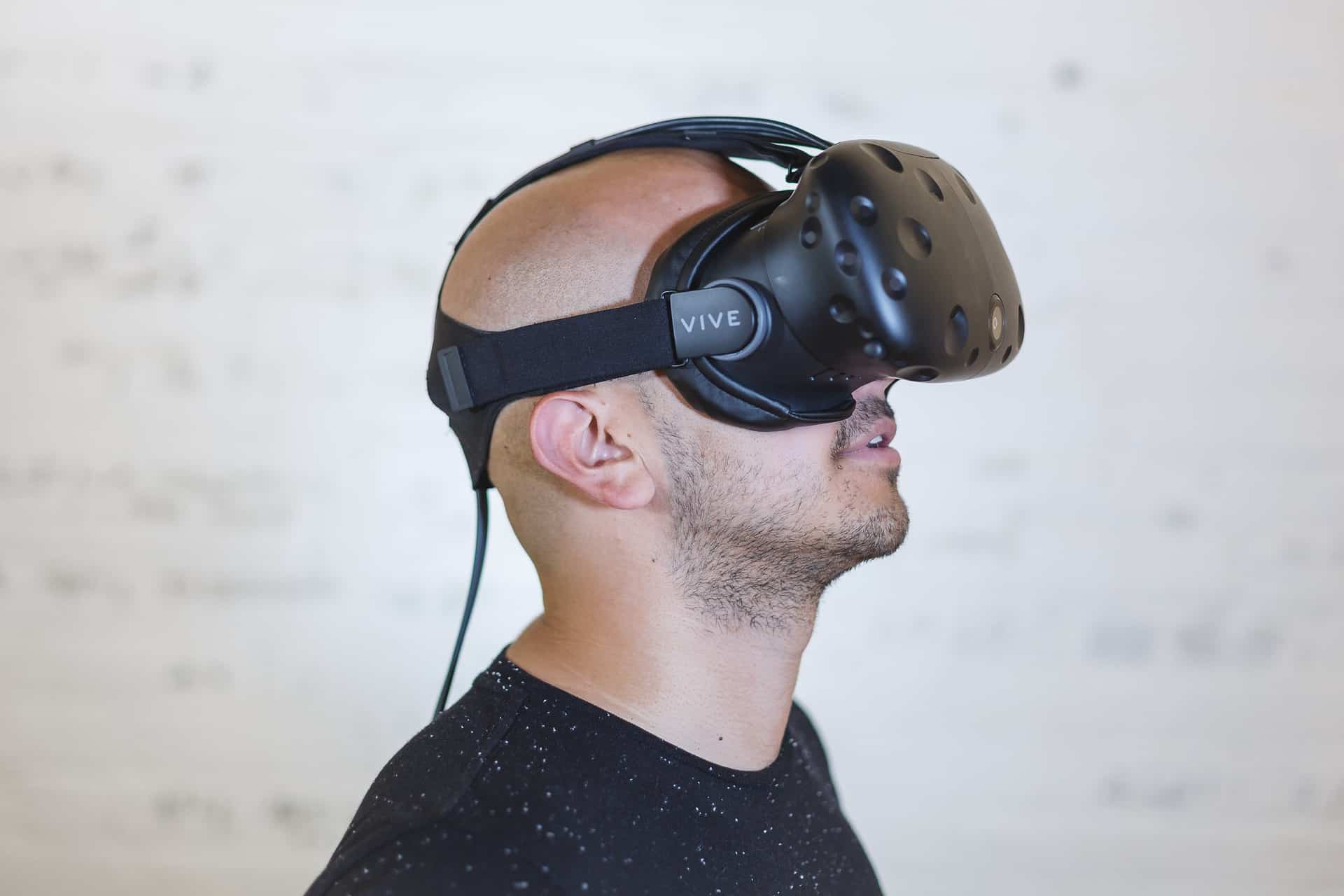 Man wearing an HTC Vive virtual reality headset looking upward, illustrating augmented and virtual reality technology