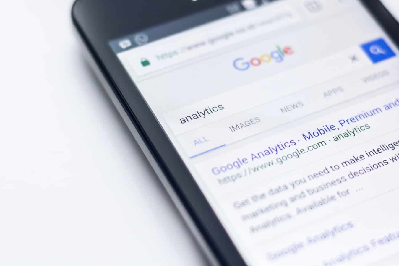 Smartphone displaying Google search results for analytics, illustrating mobile search